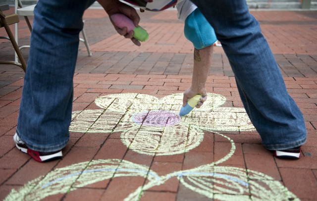 Lynnie B uses chalk to draw artwork in the diag of Michigan campus during the seventh annual P.E.A.C.E. Day on Sunday. "It's a step in the right direction to bring people together and spread peace around," says Kevin Szawala, a.k.a Mr. Peace,  who has run the event for seven years. Daniel Brenner I AnnArbor.com